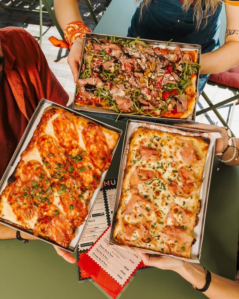 Two freshly baked pizza trays seen from above